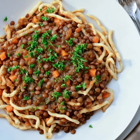 Zartes Spätzle serviert mit würziger deutscher Linsensuppe, ideal für gemütliche Abende.